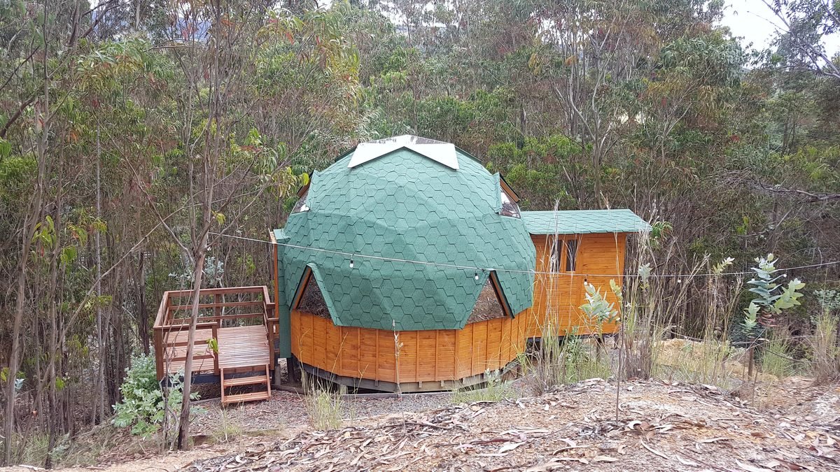 Domo geodésico con cúpula verde entre los eucaliptos, cerca de Sogamoso